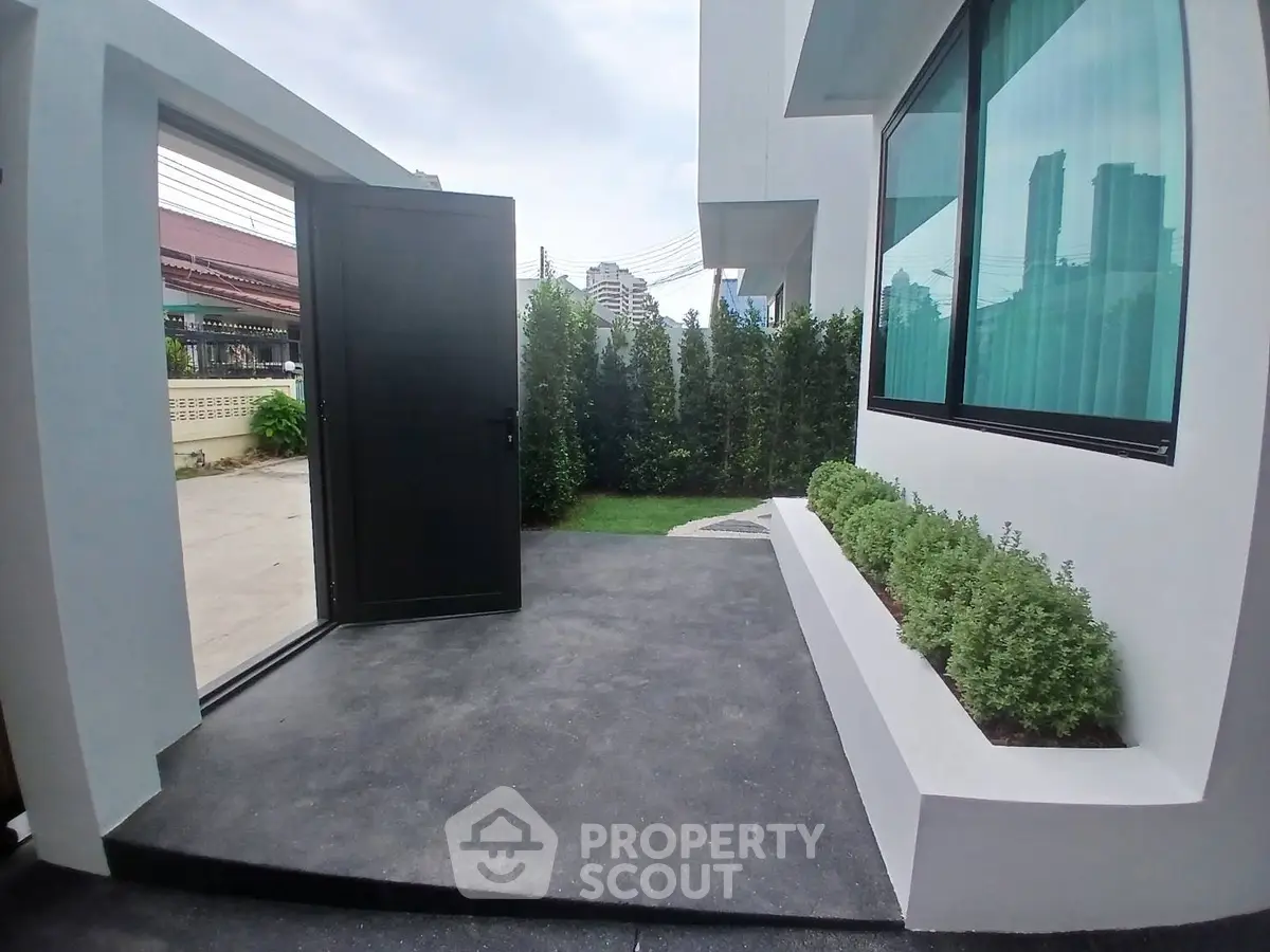 Modern building entrance with sleek design and lush greenery