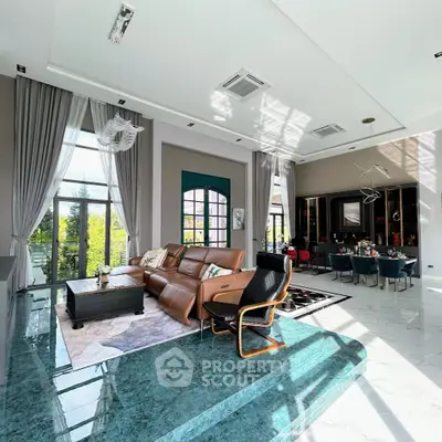 Luxurious living room with high ceilings, elegant decor, and large windows offering abundant natural light.