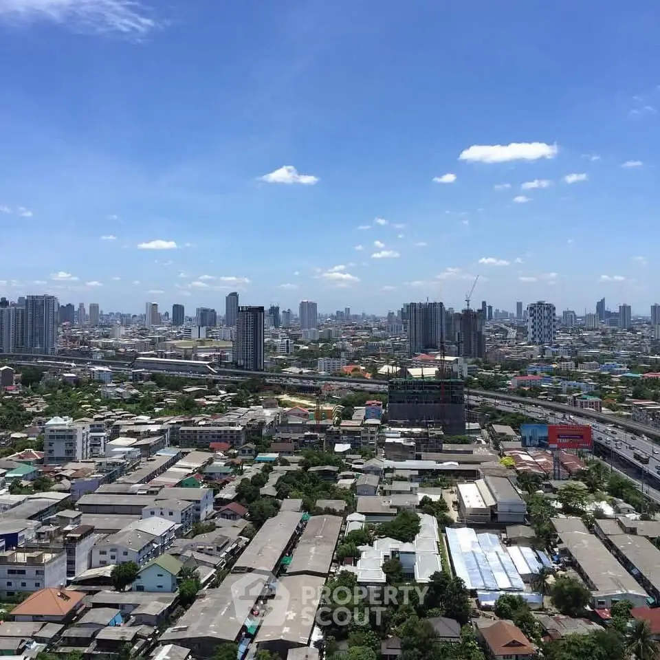 Stunning cityscape view showcasing urban skyline and residential areas under a clear blue sky.