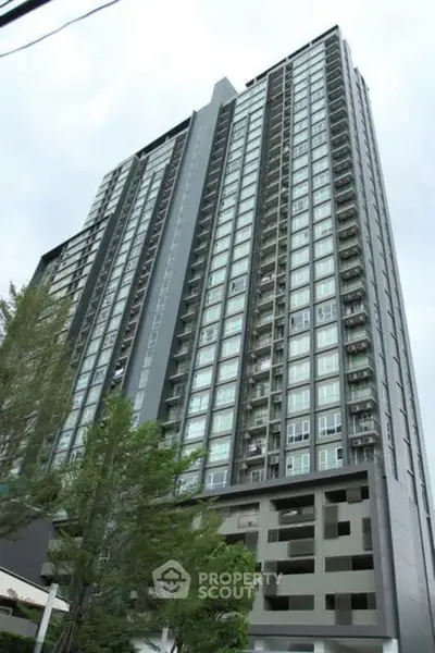 Modern high-rise condominium building with sleek design and large windows.