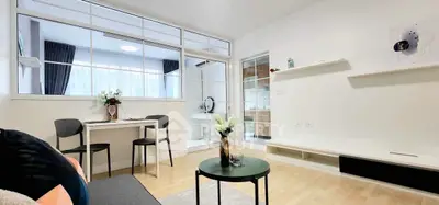 Modern living room with sleek furniture and large windows for natural light.