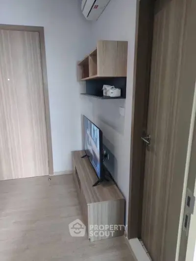 Modern minimalist living room with sleek wooden furniture and mounted TV, perfect for cozy urban living.