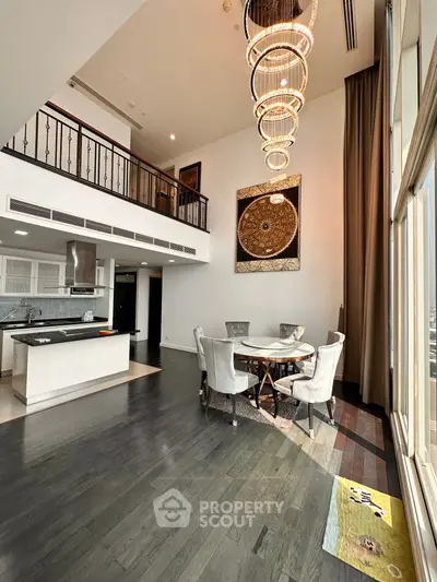Luxurious open-plan living room with high ceilings and elegant chandelier in modern apartment.