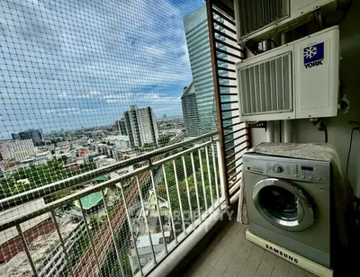 High-rise balcony with city view and washing machine, perfect urban living.