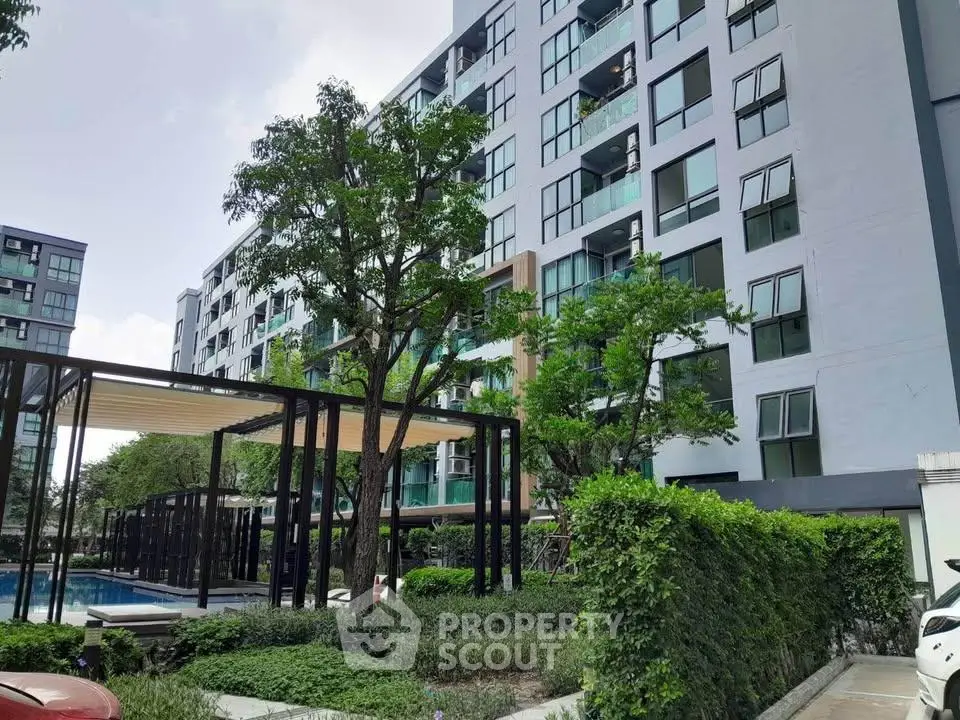 Modern apartment building with lush greenery and outdoor pool area