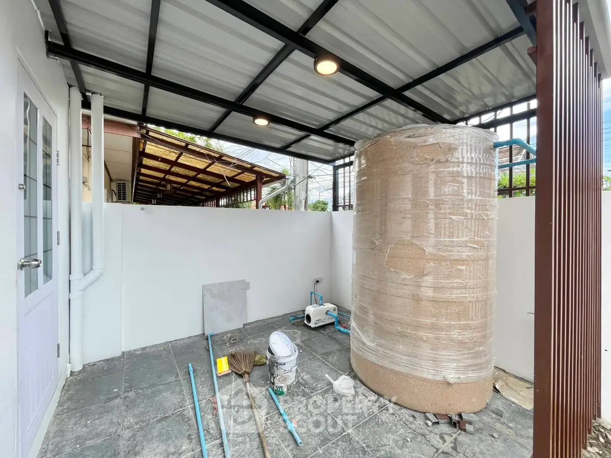 Spacious outdoor utility area with water tank and tools, ideal for home maintenance.