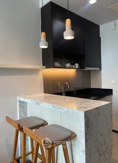 Modern kitchen with marble island and stylish pendant lights