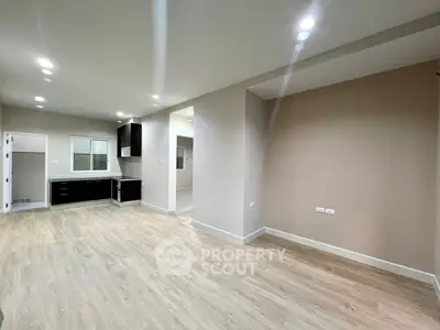 Spacious modern living room with open kitchen layout and sleek wooden flooring