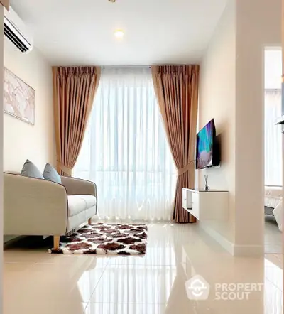 Modern living room with elegant curtains, cozy sofa, and wall-mounted TV in a bright apartment.