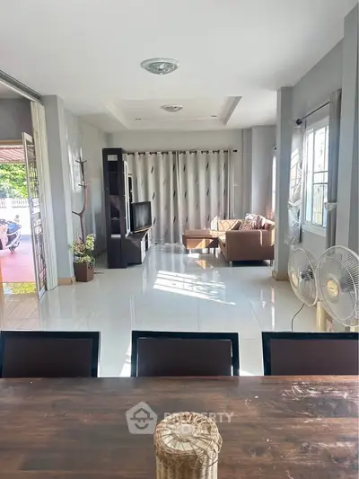 Spacious living room with modern decor and ample natural light.