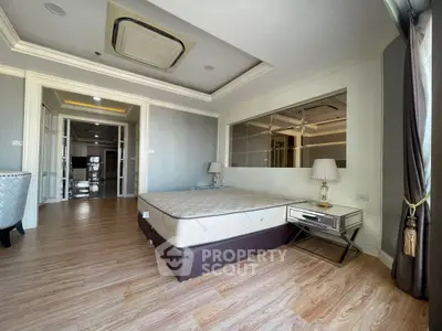 Spacious bedroom with elegant decor and large windows in a modern apartment.