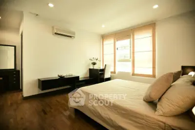 Spacious bedroom with modern decor and natural light in a stylish apartment.
