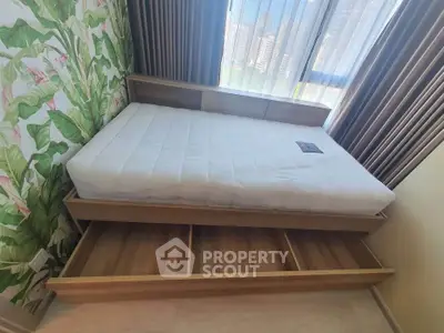 Cozy bedroom with stylish bed and tropical wallpaper, perfect for urban living.
