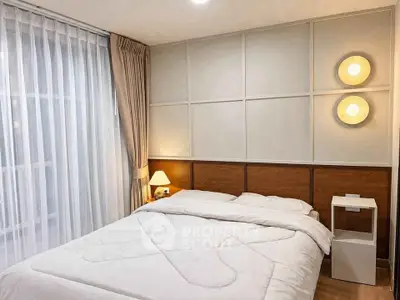 Cozy bedroom with modern lighting and elegant decor, featuring a comfortable bed and stylish bedside table.