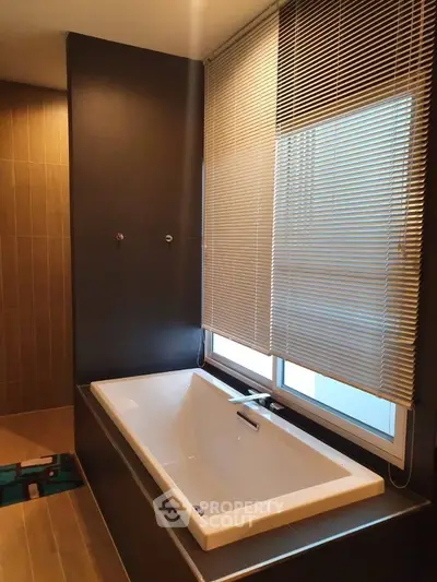 Modern bathroom with sleek bathtub and wooden accents