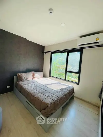 Cozy bedroom with large window and modern decor, featuring a comfortable bed and air conditioning.