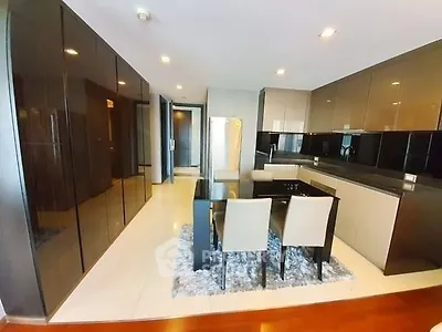 Modern kitchen with sleek cabinetry and dining area in luxury apartment