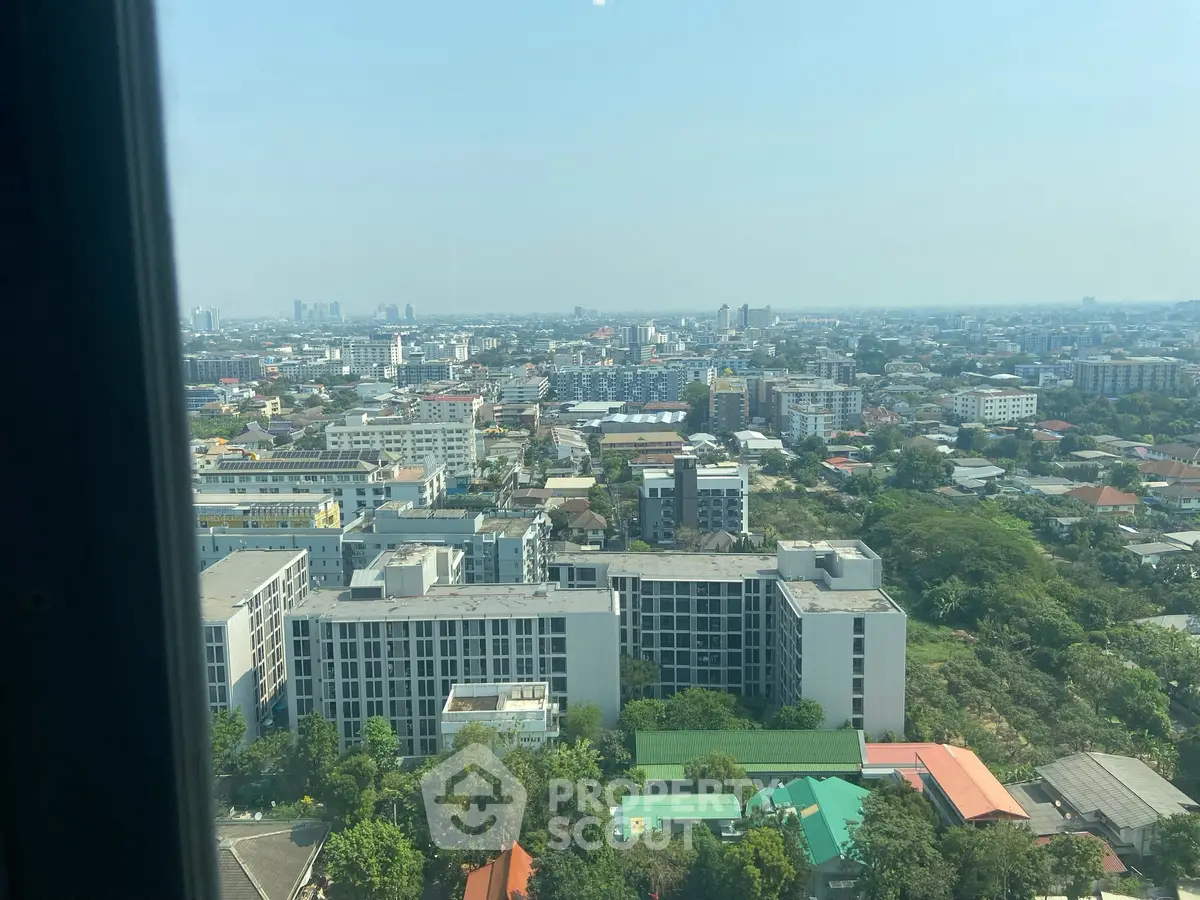 Stunning cityscape view from high-rise building, showcasing urban living with expansive skyline and lush greenery.