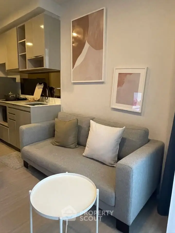 Modern living room with cozy sofa and stylish kitchen in open layout apartment.