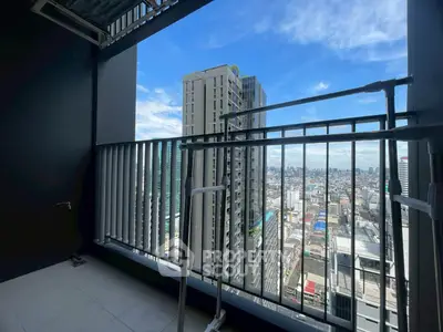Stunning city view from high-rise balcony with modern railing and clear blue sky.