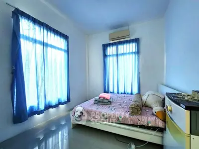 Cozy bedroom with natural light and air conditioning, perfect for relaxation.