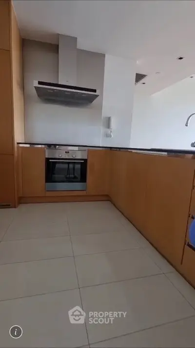 Modern kitchen with sleek cabinetry and built-in oven in a contemporary apartment.