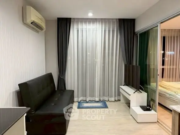 Modern living room with sleek black sofa, air conditioning, and floor-to-ceiling windows in a stylish apartment.