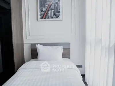 Modern bedroom with sleek design and cityscape artwork, featuring natural light through large windows.