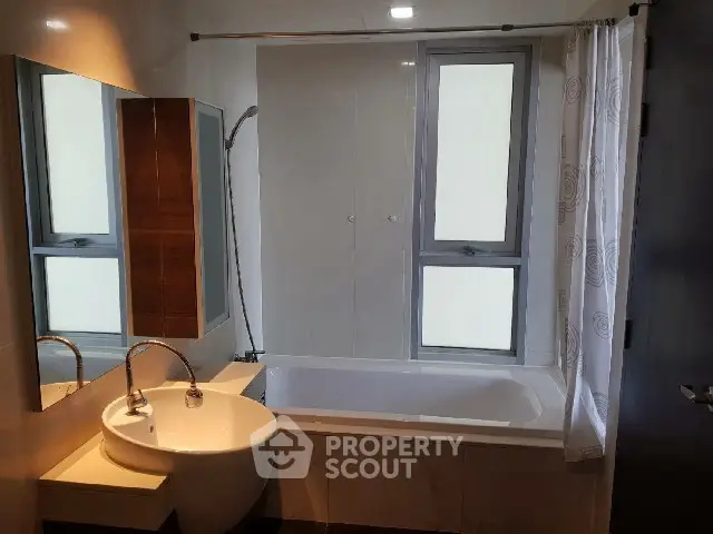 Modern bathroom with bathtub and stylish sink in a well-lit space.