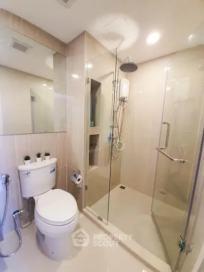 Modern bathroom with glass shower and sleek fixtures in a contemporary apartment.