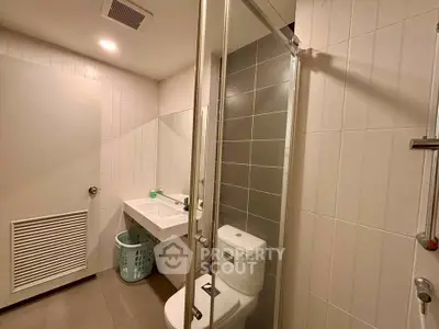 Modern bathroom with sleek design, featuring a glass shower and contemporary fixtures.