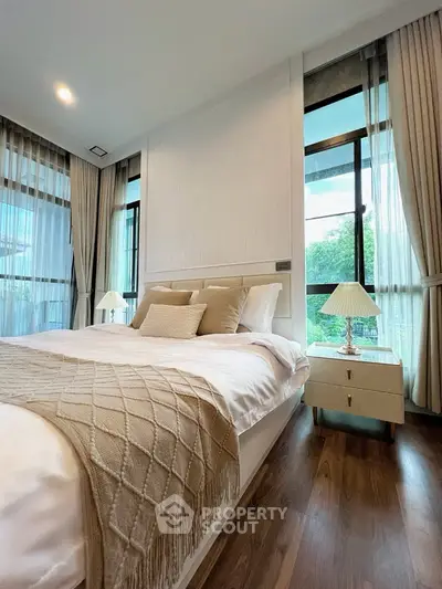 Luxurious bedroom with elegant decor and large windows offering natural light and serene views.