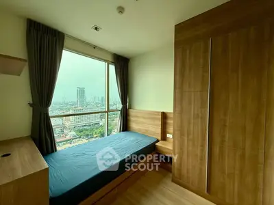 Modern bedroom with wooden furniture and stunning city view from large window.