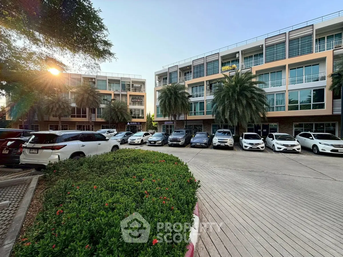 Modern residential complex with ample parking and lush greenery, showcasing contemporary architecture and urban living.