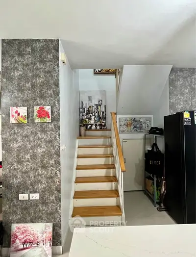 Stylish interior with modern staircase and artistic wall decor in a contemporary home.