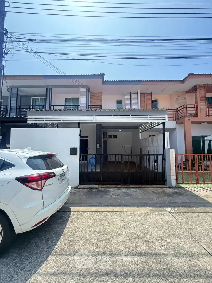 Modern townhouse exterior with carport and gated entrance in a sunny neighborhood.
