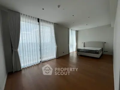 Spacious bedroom with large windows and elegant curtains in modern apartment