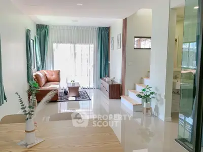 Modern living room with elegant decor and natural light, featuring a cozy seating area and stylish dining space.