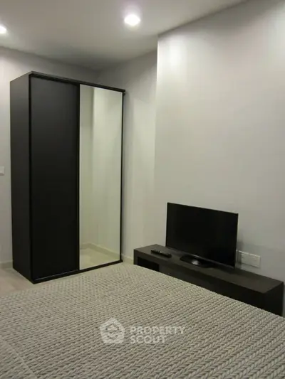 Modern bedroom with sleek wardrobe and flat-screen TV