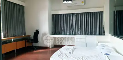 Spacious bedroom with modern furnishings and large windows in a stylish apartment.