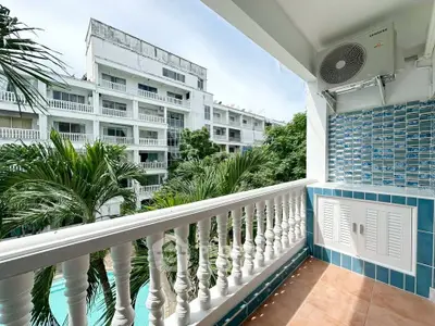 Charming balcony with pool view in tropical setting, perfect for relaxation.