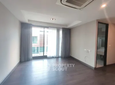 Spacious empty room with large window and modern bathroom access