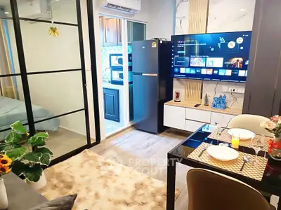 Modern open-plan living room with sleek kitchen and dining area, featuring stylish decor and smart TV.