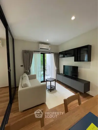Modern living room with sleek furniture and balcony view, perfect for urban living.