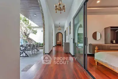 Luxurious villa with elegant hallway and outdoor dining area, featuring wooden flooring and modern decor.