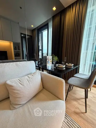 Modern living room with cozy seating and elegant dining area, featuring floor-to-ceiling windows and stylish decor.