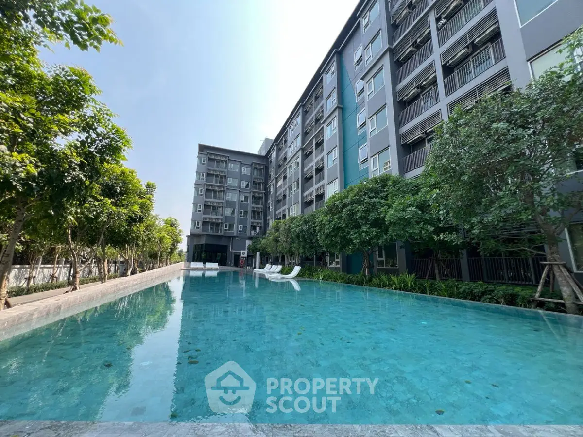 Modern apartment building with a stunning pool and lush greenery, perfect for relaxation and leisure.