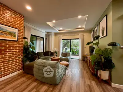 Spacious living room with modern decor and garden view, featuring cozy seating and stylish brick accent wall.