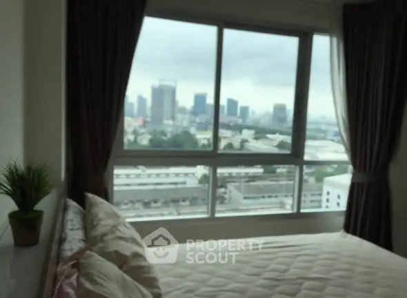 Cozy bedroom with city view through large window, perfect for urban living.