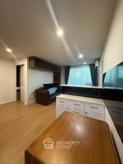 Modern living room with wooden flooring and stylish furniture in a cozy apartment setting.